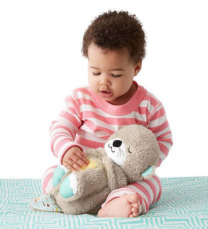 Fisher-Price Soothe 'n Snuggle Otter held by baby with white background