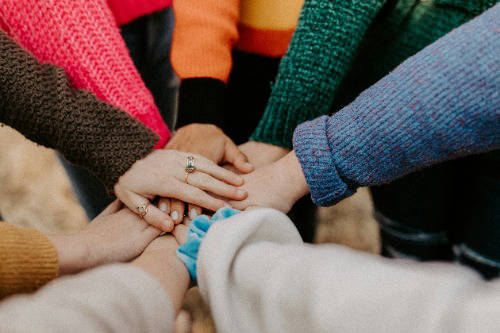 People with their hands in a circle on top of each other